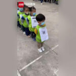 Cina: Bambini di un asilo in una lunga fila ordinata con un QR CODE sul petto