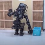 Robot umanoide monta una lastra di cartongesso su una parete. La robotica potrebbe presto sostituire la manodopera umana