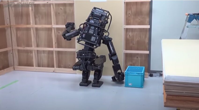 Robot umanoide monta una lastra di cartongesso su una parete. La robotica potrebbe presto sostituire la manodopera umana