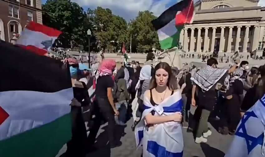 Con la bandiera israeliana si infila tra i pro-Palestina per provocarli, ma viene completamente ignorata.