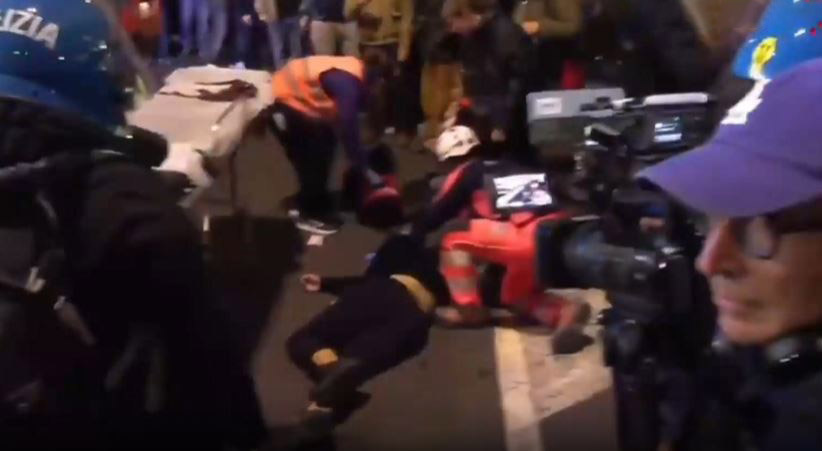 Bologna: la polizia aziona gli idranti verso un’ambulanza impegnata nelle operazioni di soccorso di un giovane in gravi condizioni.